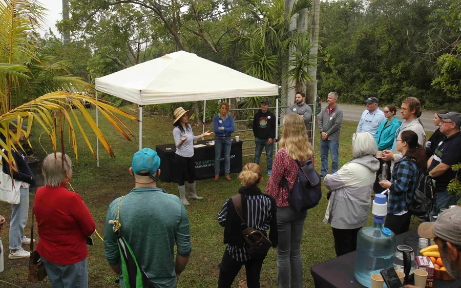 A Fertile Earth farm tour group gathered under a tent at the farm
