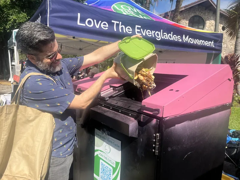 A resident emptying food scraps into a Love The Everglades community compost hub
