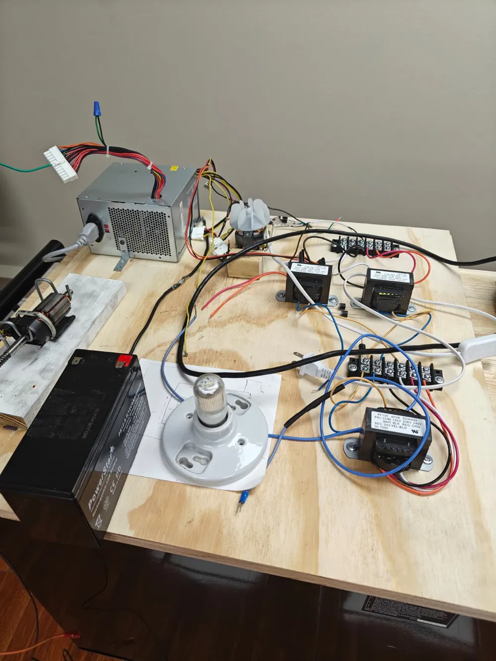 A practice wiring board with relays, a light fixture and wire on a lab workbench at Florida Professional Institute