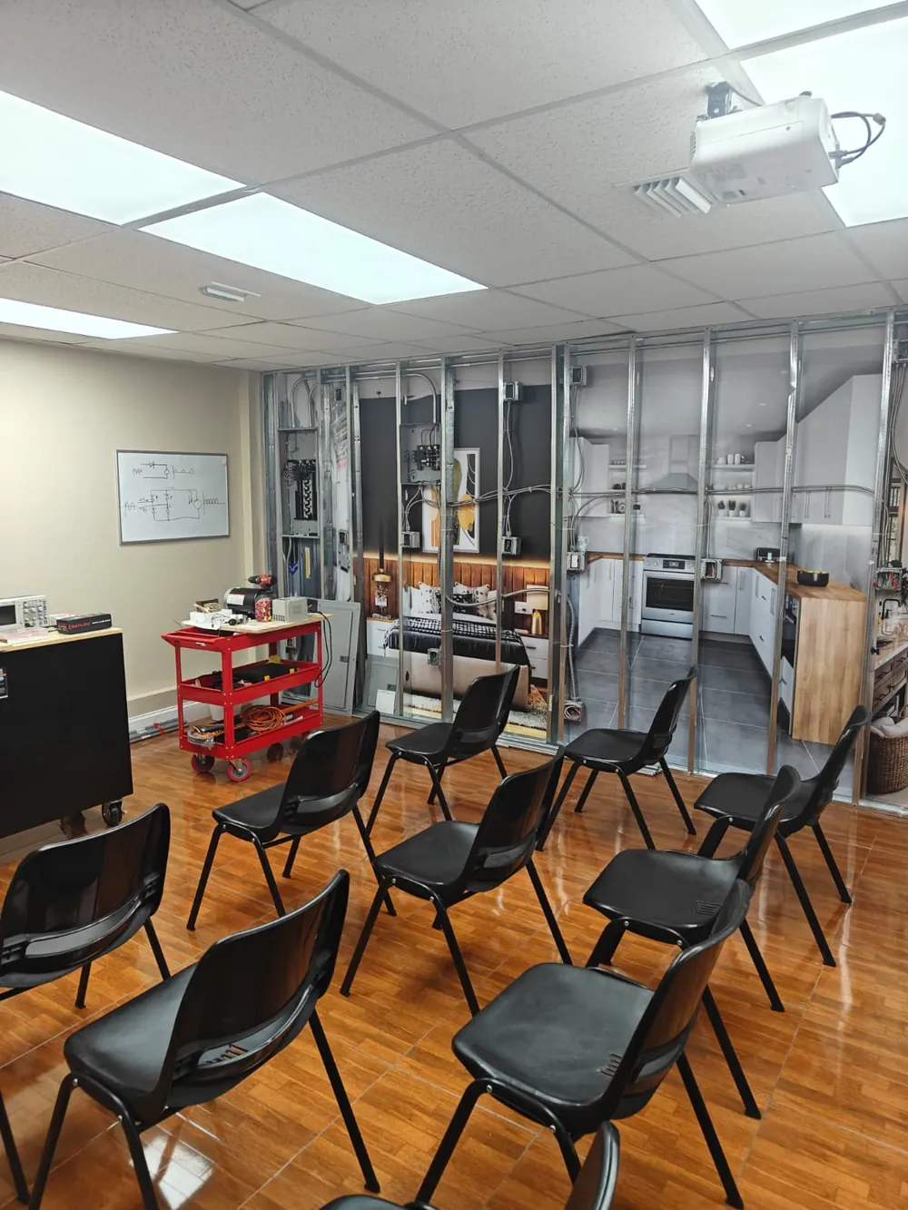 Electrical lab classroom at Florida Professional Institute: student chairs facing a steel stud wiring wall