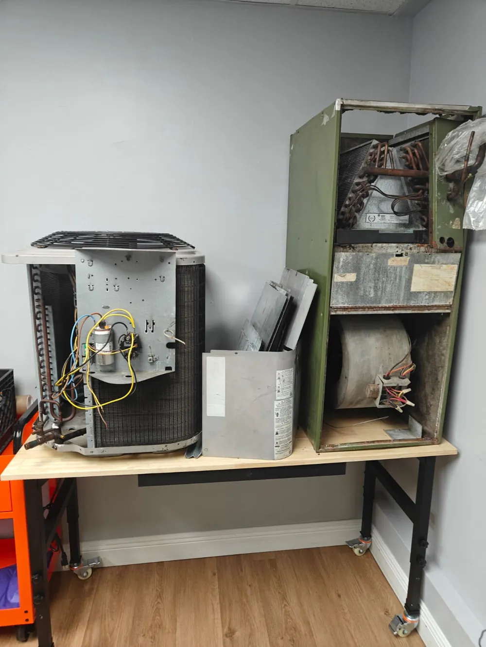 Condensing unit and an opened air handler on a workbench in the air conditioning lab
