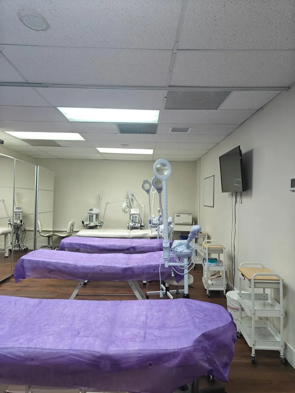 Treatment lab at Florida Professional Institute seen from the doorway, with tables, lamps and carts